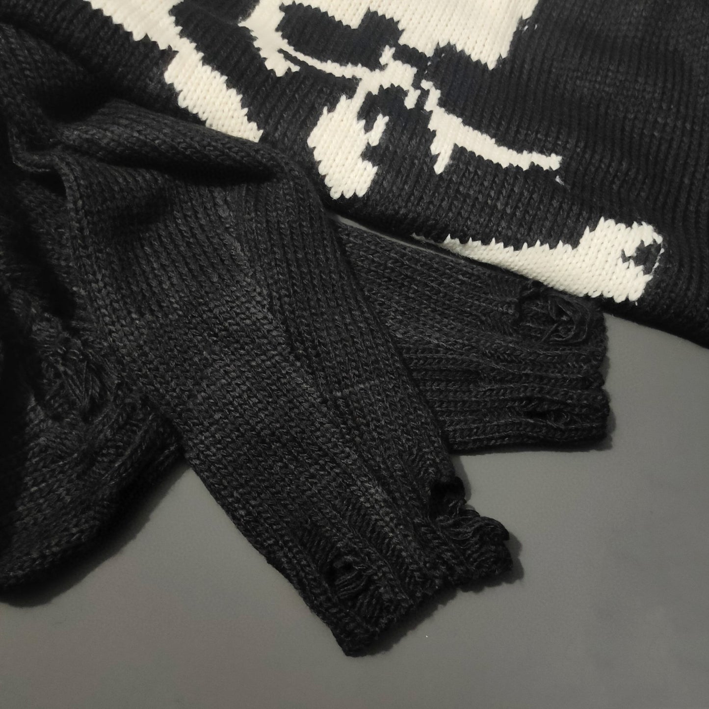 Pullover mit dunklem Totenkopf und zerrissenem dickem Faden